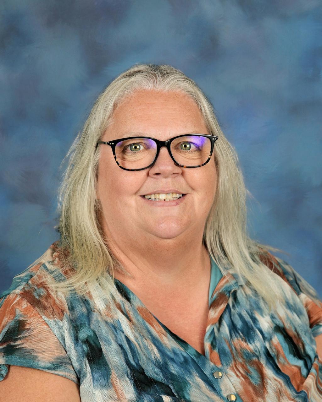 Woman with long hair, glasses and a colorful shirt